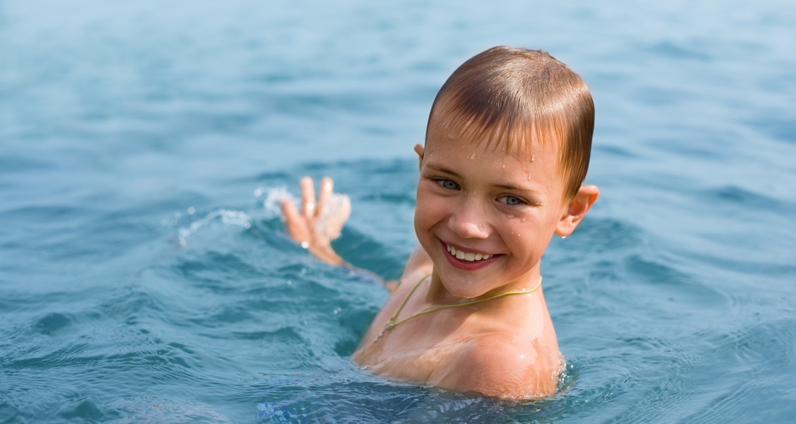 Happy boy swimming in sea.