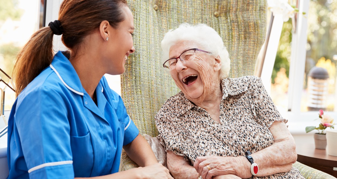 Bild: sköterska och äldre kvinna skrattar tillsammans