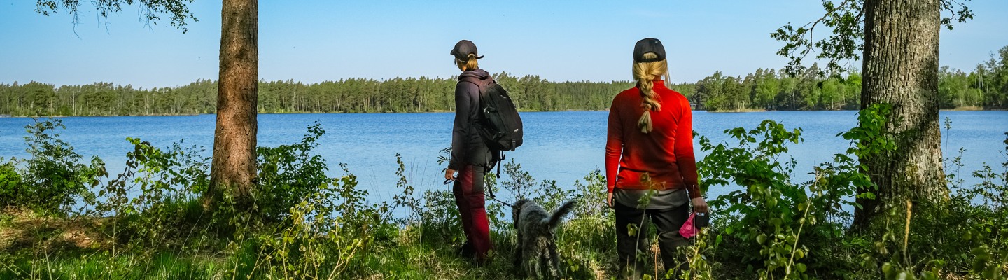 Några personer som står vid en sjö.