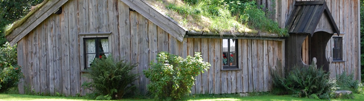 Ett hus med ett grönt tak och ett grästak.